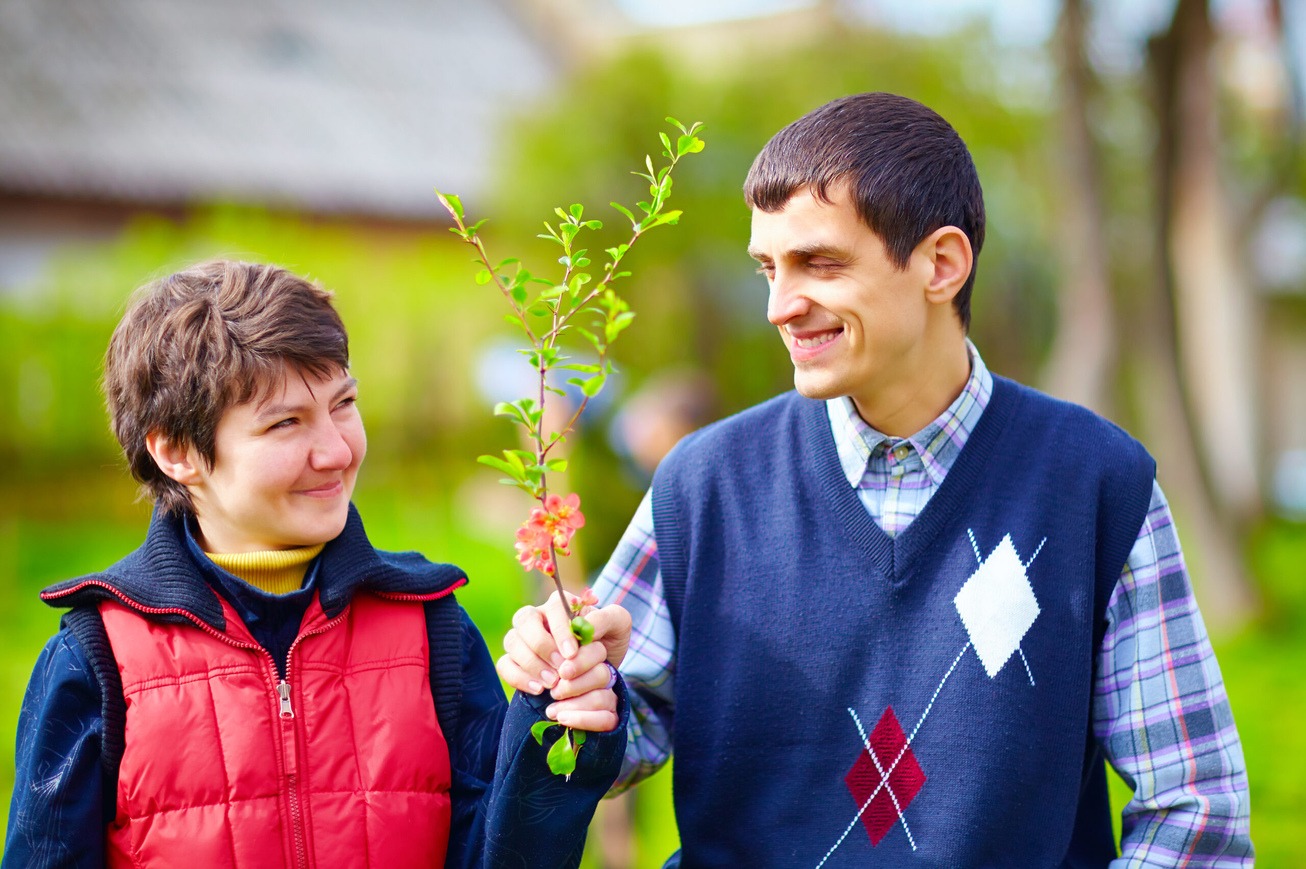portrait of happy woman and man with disability together on spring lawn